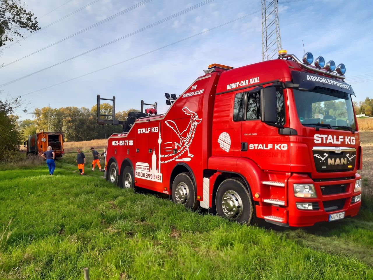 Roter MAN-Schwerlast-Bergewagen der STALF KG im Einsatz am Straßenrand – Unfallfahrzeuge gelangen so in die eigene Verwertung