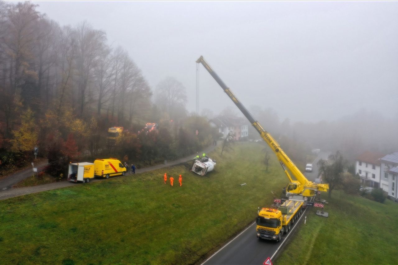 Kranbergung an einem Hang im Nebel mit Autokran und Bergefahrzeugen der STALF Gruppe