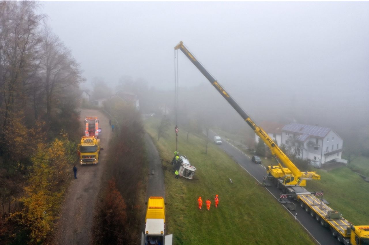 Autokran und Bergefahrzeuge der STALF Gruppe bei einem Einsatz im Nebel an einer Landstraße